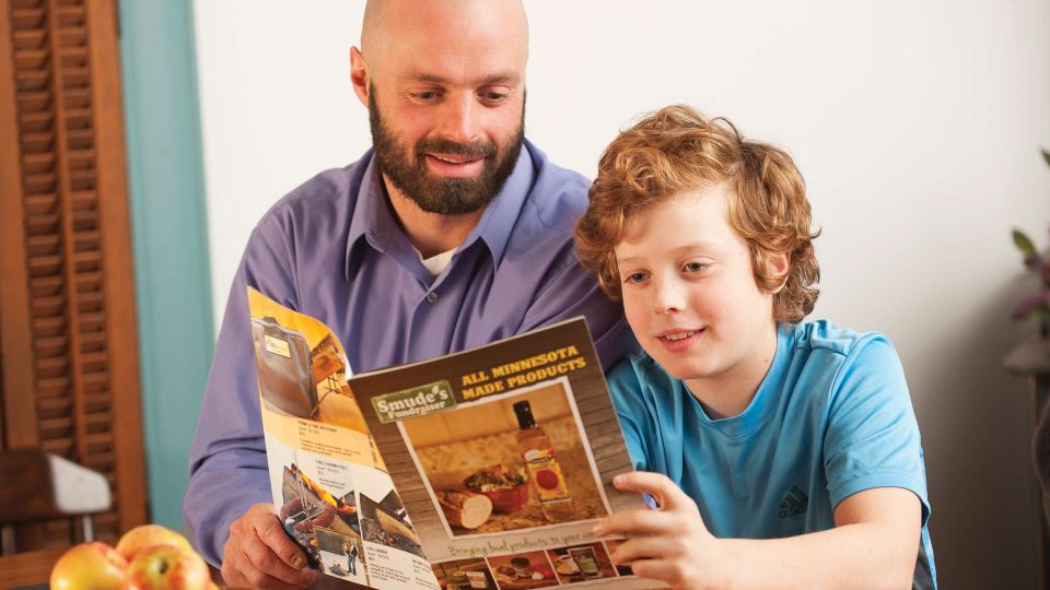 man reading brochure to a little boy