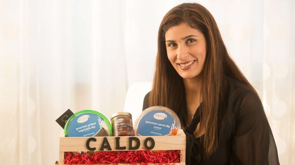 woman holding various food products from Caldo foods