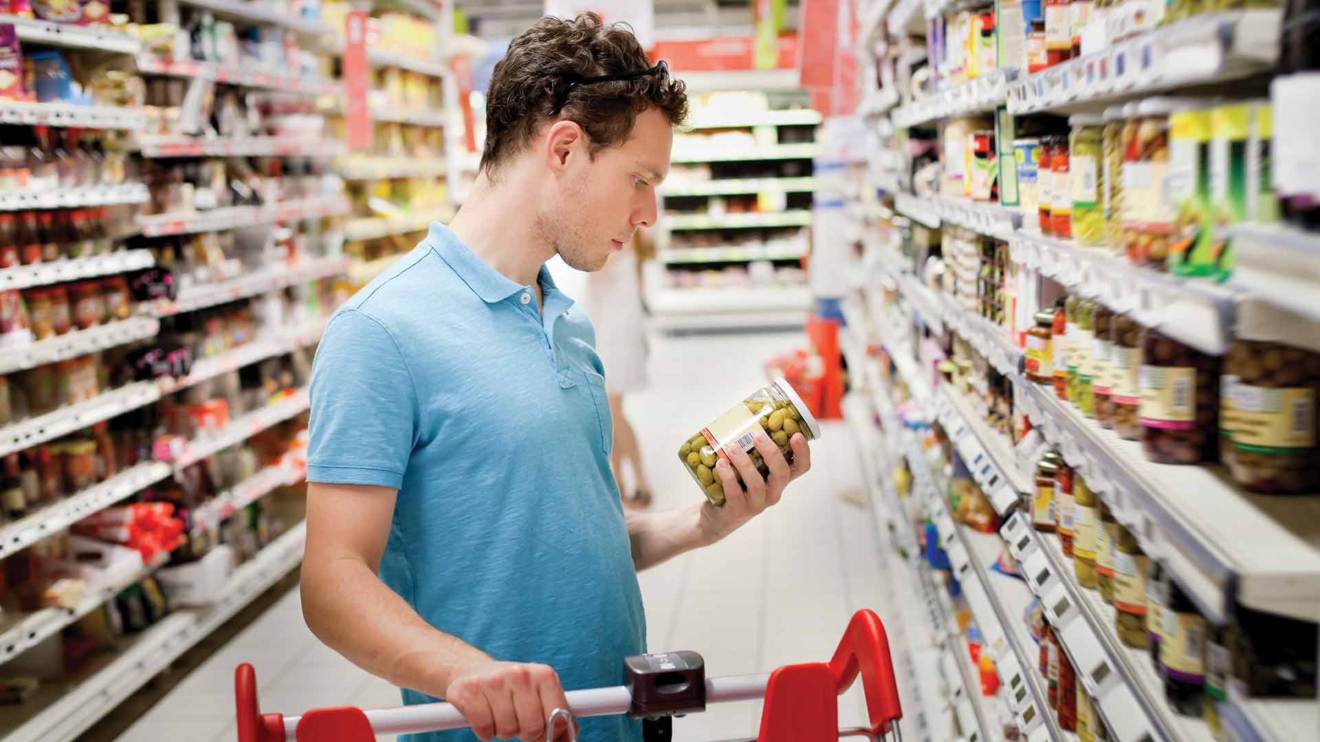 man looking at label in grocery store