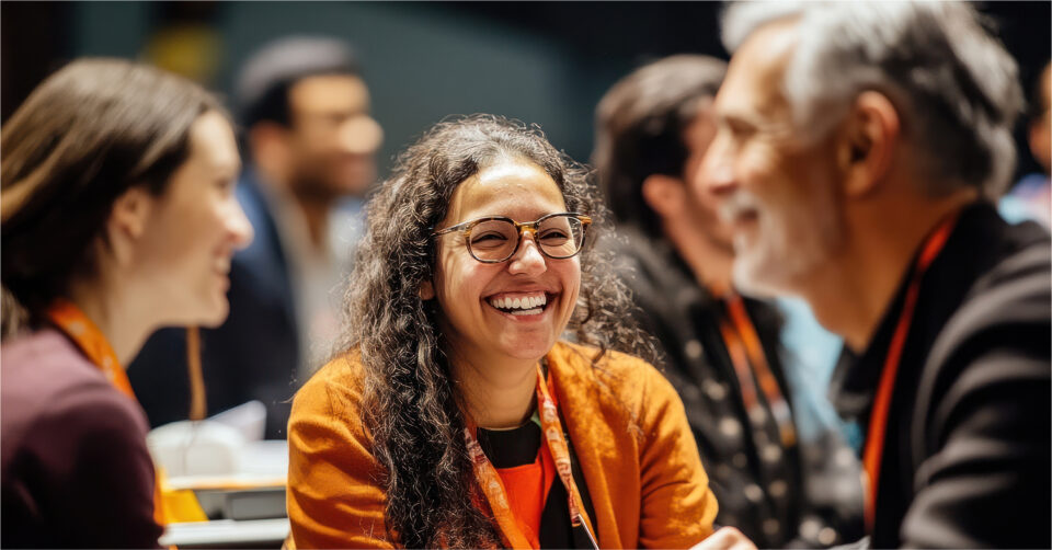 Smiling woman in glasses talking with colleagues at a conference